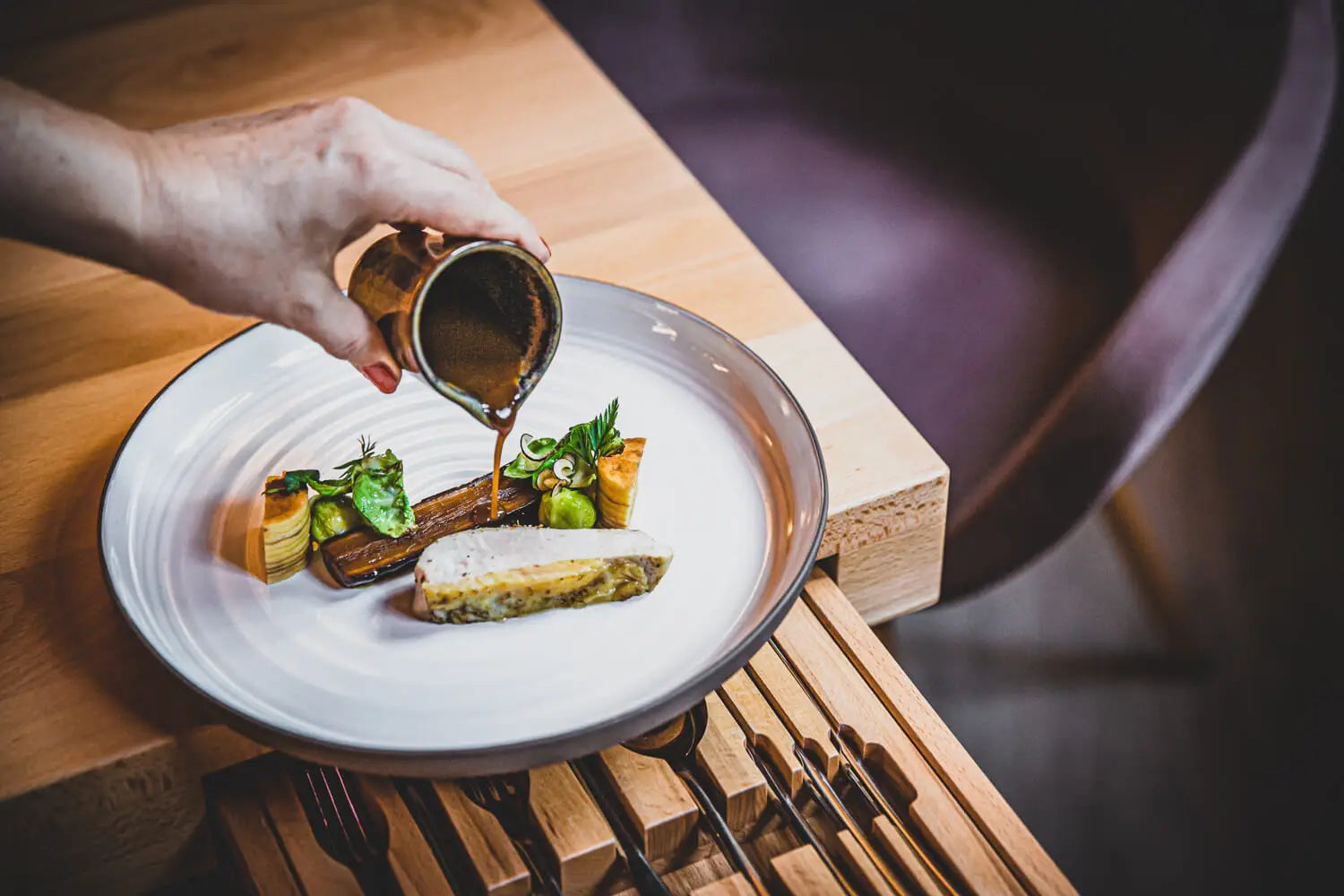Gericht aus der Sterneküche des Genuss-Atelier Dresden, die Sauce wird am Tisch angegossen